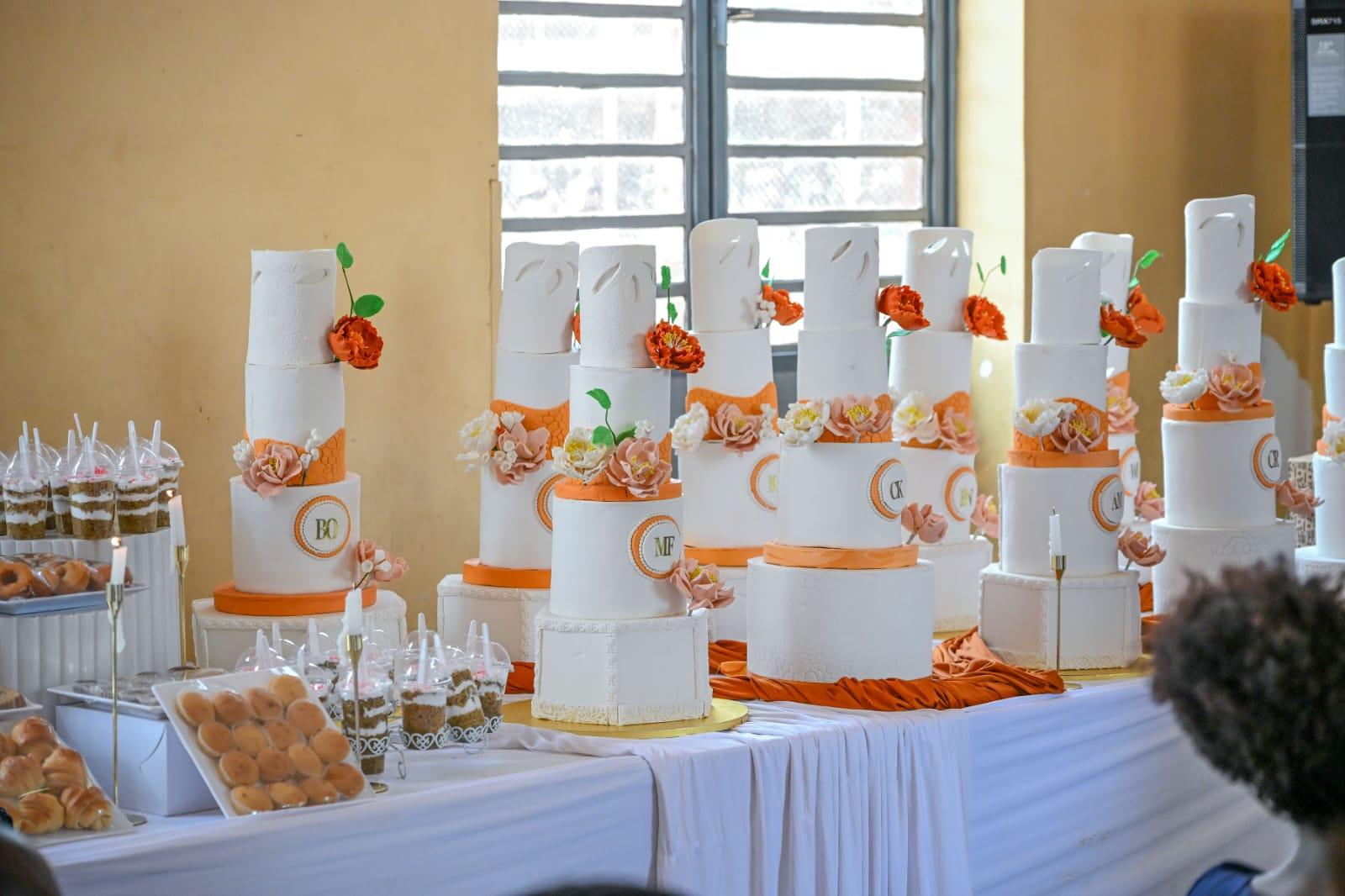 A display of elegant multi-tier wedding cakes decorated by Modesh Empowerment Hub students